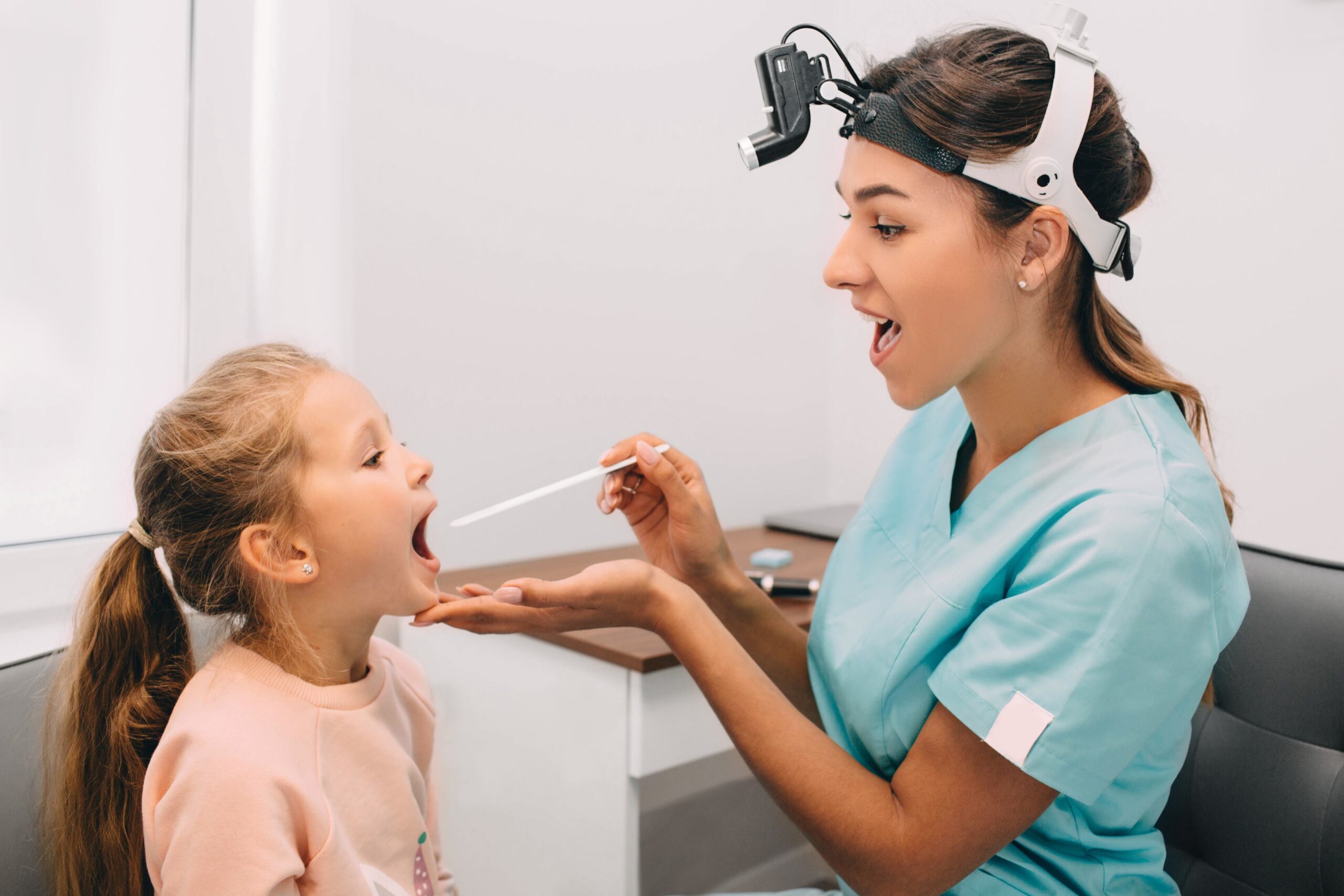 Dentist performing a dental exam and explaining oral hygiene importance